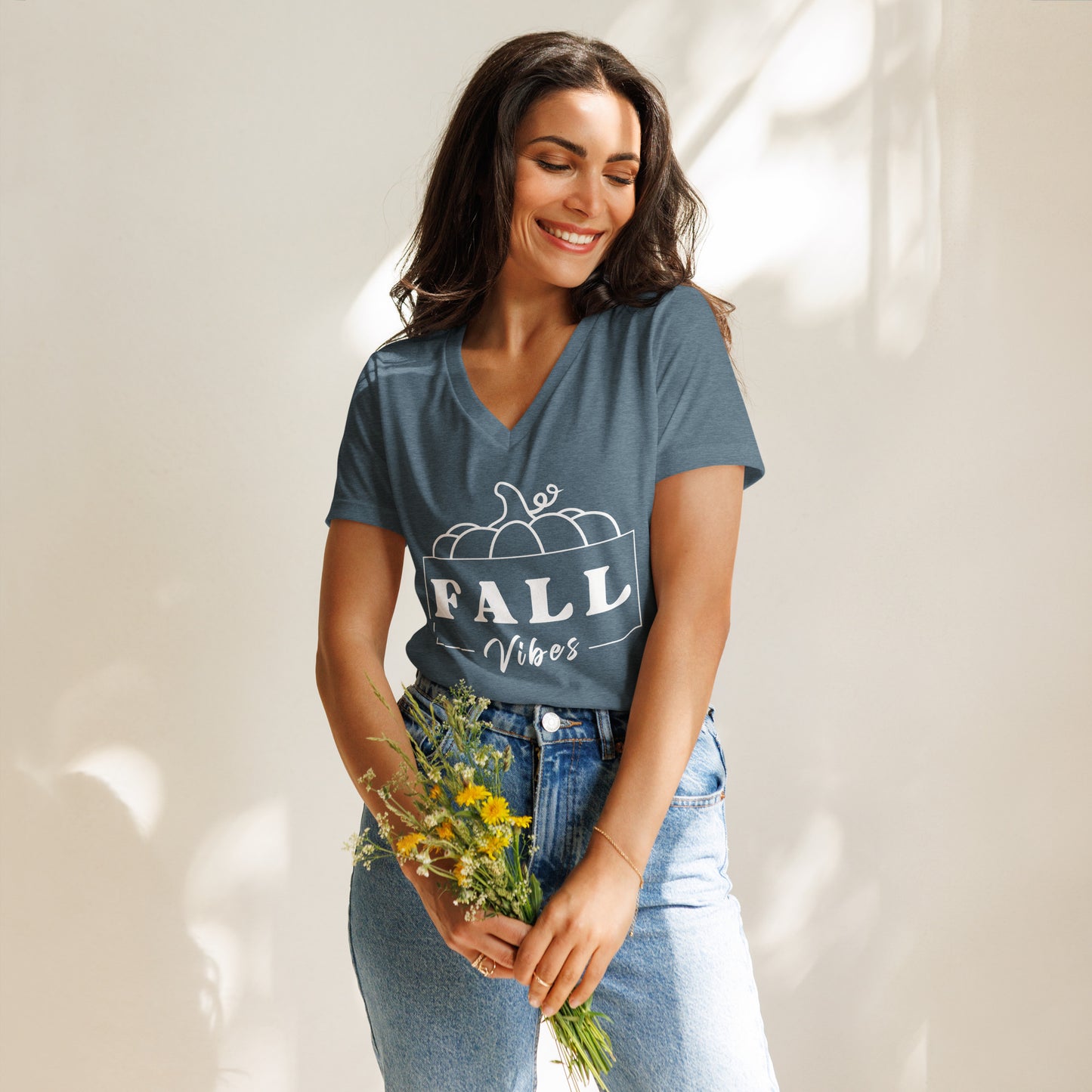 Fall-themed, heather blue V-neck shirt that says "Fall Vibes" with white frame around it and a pumpkin on top.