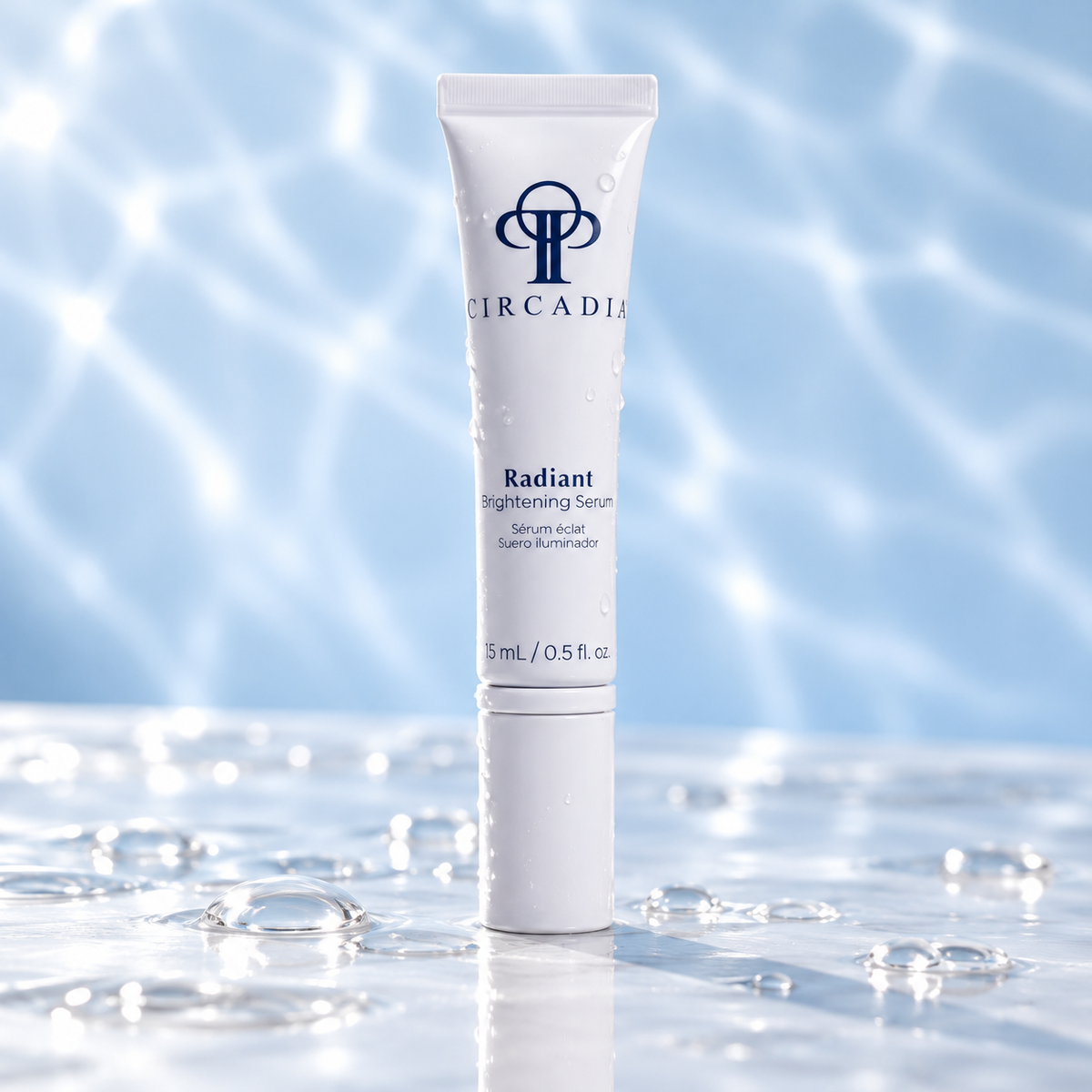 A 15 mL white squeeze tube of Circadia Radiant Brightening Serum standing upright on a glossy wet surface with water droplets and a blue water-ripple background.