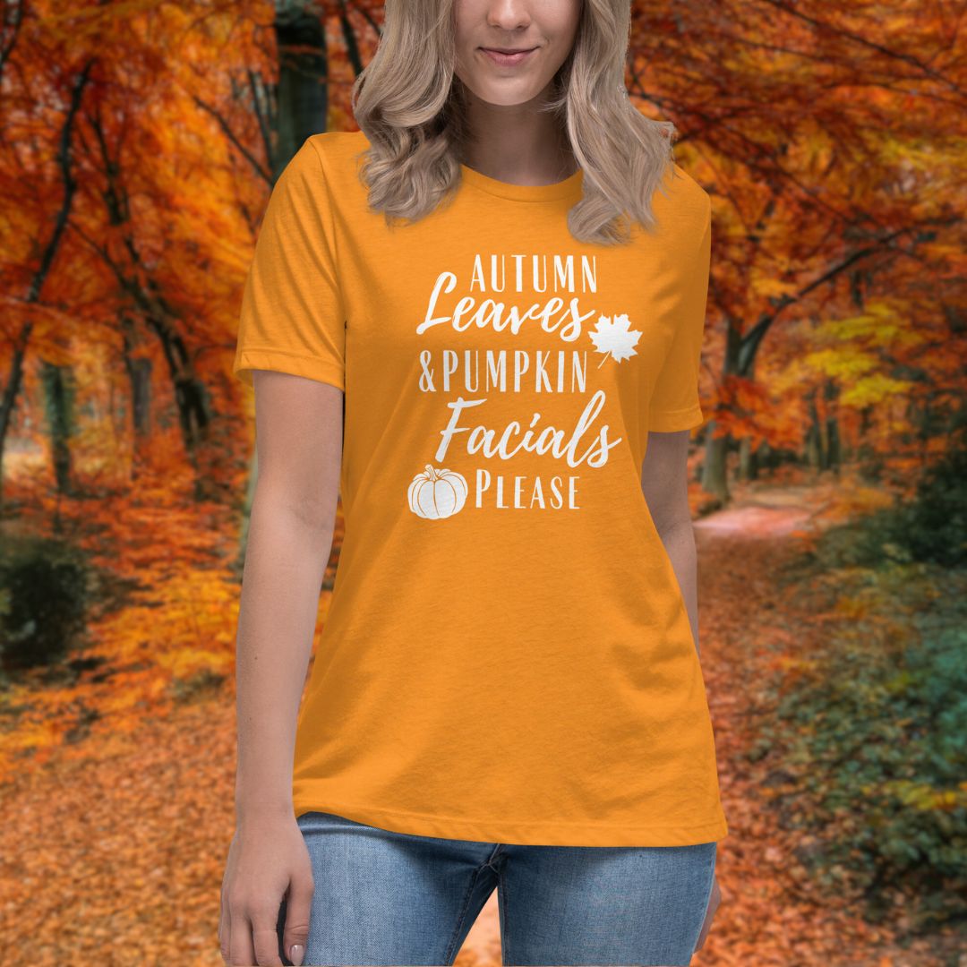 A orange t-shirt featuring autumn leaves, a pumpkin, and the words "Autumn Leaves and Pumpkin facials please" in a formal font.